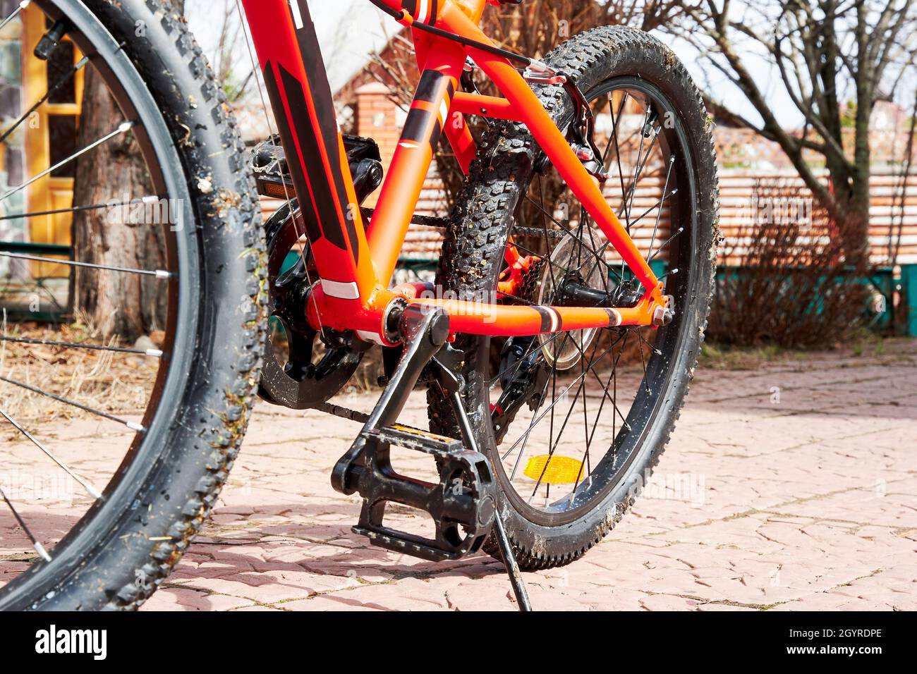 Rotes schmutziges Mountainbike im Garten. Extremsport und Freizeitaktivitäten Stockfoto