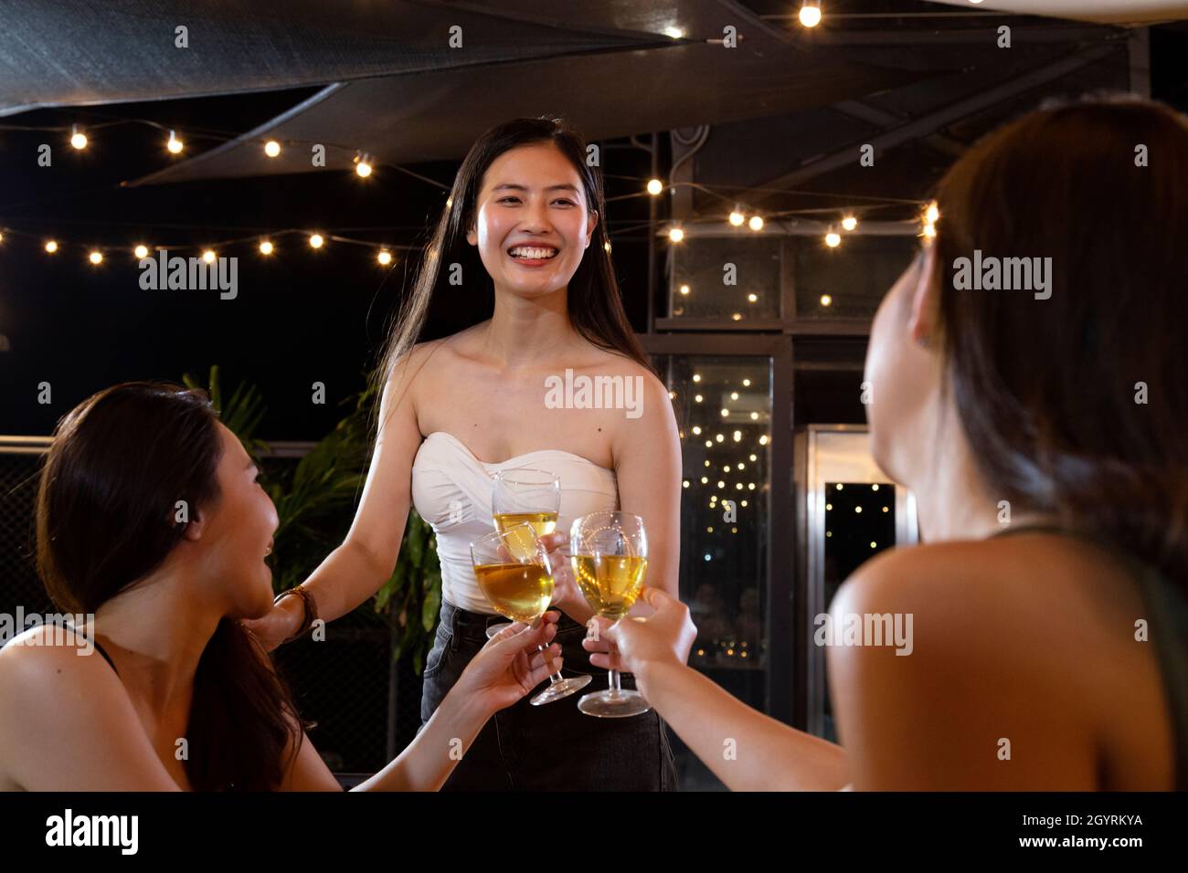asiatische Frau Jugendliche jubeln und Toast mit weißen Sekt Glas zu feiern bei Dinner-Party im Sommer. Feier, Beziehung und f Stockfoto