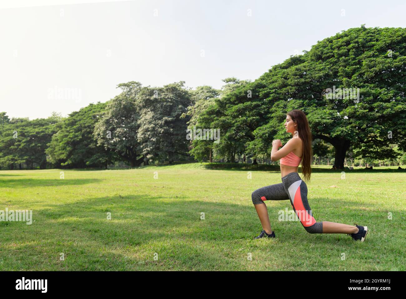 Gesunde junge Teenager-Mädchen Stretching Arme Training und Aufwärmen vor Fitness-Training im Park am Sonntagmorgen. Leben nach covid. Stockfoto