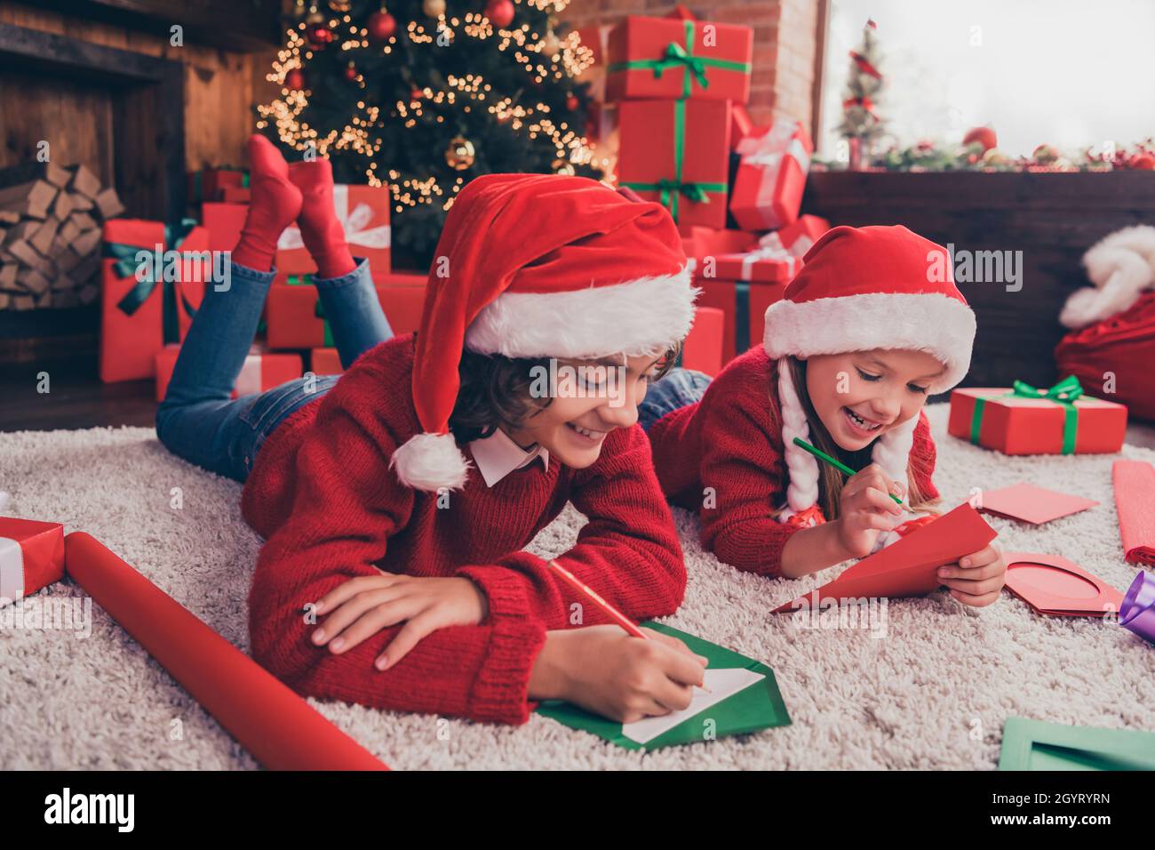 Profilseitenfoto des kleinen Kindes Bruder Schwester Liegefläche Schreiben Sie Wunschbrief an weihnachtsmann Winterurlaub drinnen Stockfoto