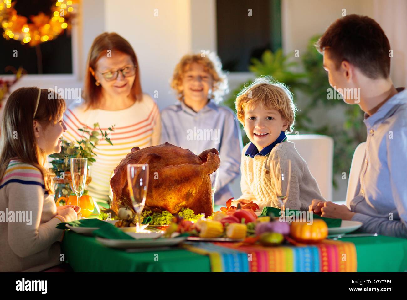 Familie am Thanksgiving-Abendessen. Eltern, Großeltern und Kinder genießen geröstete pute- und Gemüsemahlzeiten. Kinder und Großmutter Stockfoto