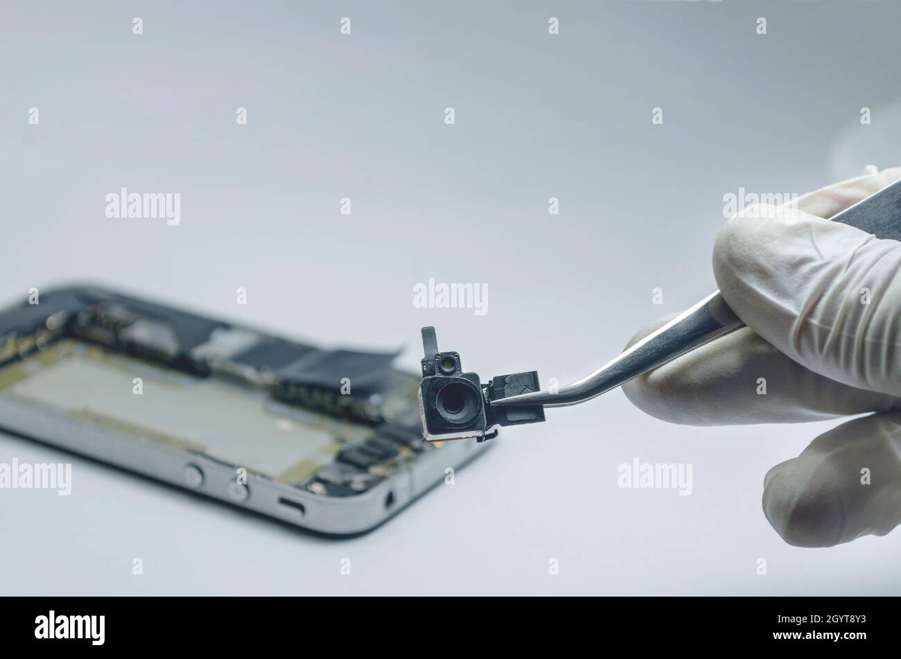 In der Nähe von Kamera Handy für die Festsetzung der Reparaturen in die Hauptplatine für Smartphone im Labor durch professionelle Techniker auf dem Schreibtisch. Mit mini Tools Stockfoto