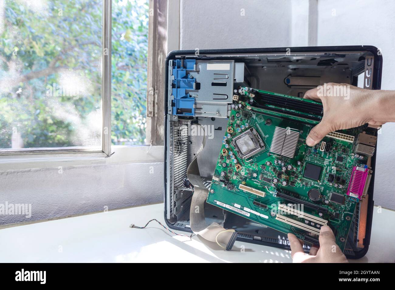 Ein junger Techniker repariert oder aktualisiert das Mainboard in einem Fall, Computer repariert pc-Computer im Service-Center. Stockfoto