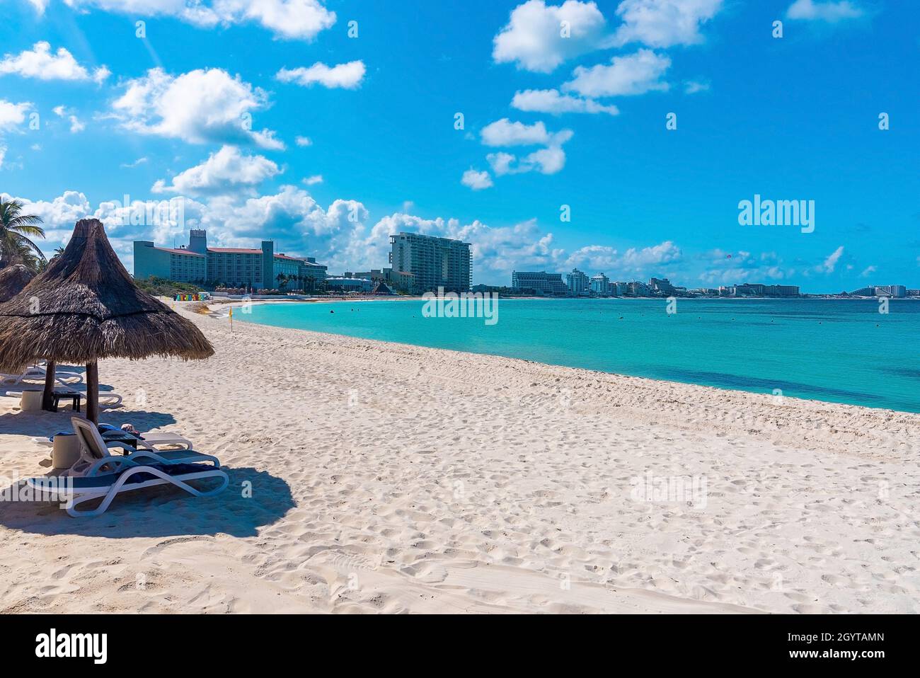 Leerer Liegestuhl und Strohdach am Strand Stockfoto