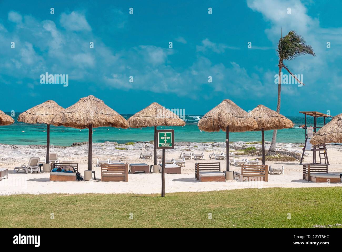 Landschaftlich schöner Blick auf das Bett unter dem Strohdach am Strand gegen das Meer Stockfoto