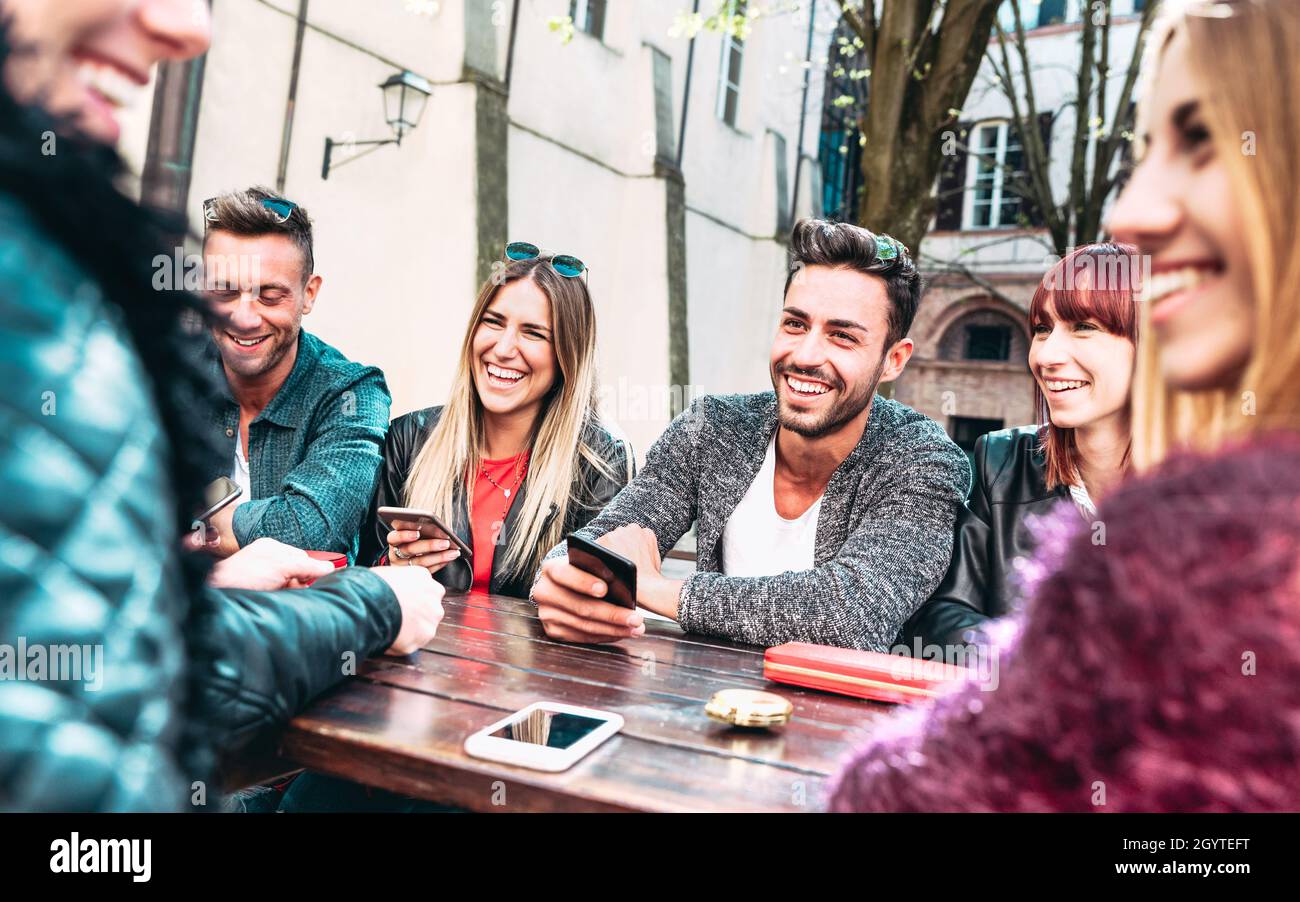 Fröhliche Freunde, die gemeinsam Spaß am Outdoor-Standort haben - Junge Menschen beeinflussen Gespräche und teilen Inhalte mit mobilen Smartphones - Friendship Co Stockfoto