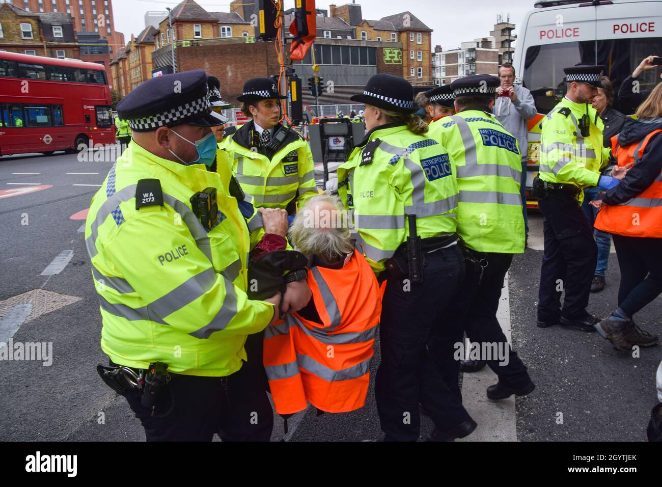 London, Großbritannien. Oktober 2021. Die Polizei entfernt und verhaftet britische Demonstranten, die sich am Kreisverkehr in der Old Street an die Straße geklebt haben. Beleidigung Großbritanniens die Demonstranten fordern, dass die Regierung bis 2025 alle sozialen Wohnungsbauten isoliert und die Verantwortung dafür übernimmt, dass alle Häuser im Vereinigten Königreich bis 2030 energieeffizienter sind, als Teil der umfassenderen Ziele für den Klimawandel und die Dekarbonisierung. Stockfoto