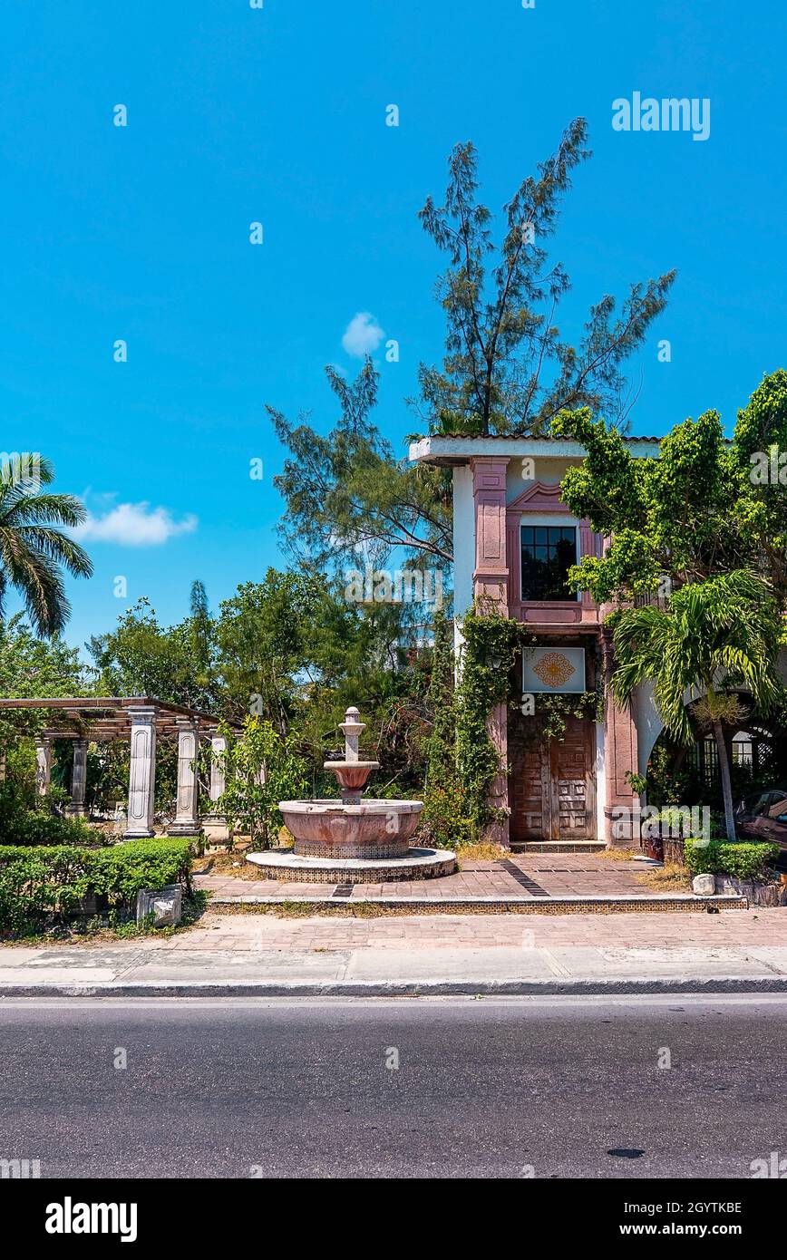 Rustikaler, verlassene Wohnbungalow im spanischen Stil und Springbrunnen am Straßenrand Stockfoto