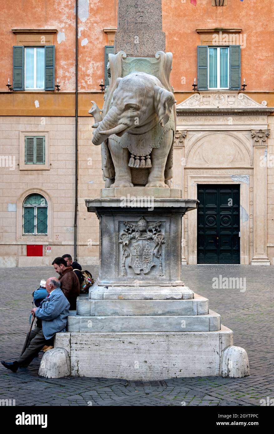 Auf der Piazza della Minerva in Rom, Italien, ruhen die Touristen neben dem Elefanten und dem Obelisken, einer barocken Skulptur von Gian Lorenzo Bernini (1667). Stockfoto