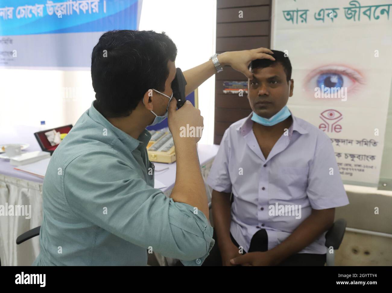 Non Exclusive: DHAKA, BANGLADESCH - 7. OKTOBER 2021: Ein Augenarzt untersucht die Augen eines Patienten während einer kostenlosen Augenbehandlung, die von National Eye organisiert wird Stockfoto