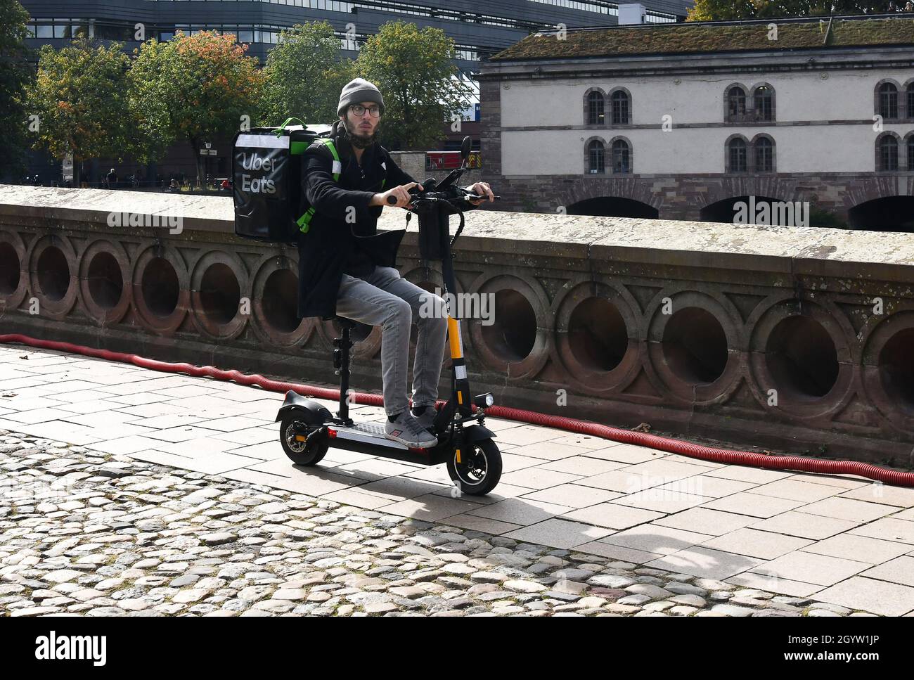 Uber isst Online-Lebensmittel Bestellung und Lieferung von Mann auf Elektroroller Straßburg, Frankreich Stockfoto