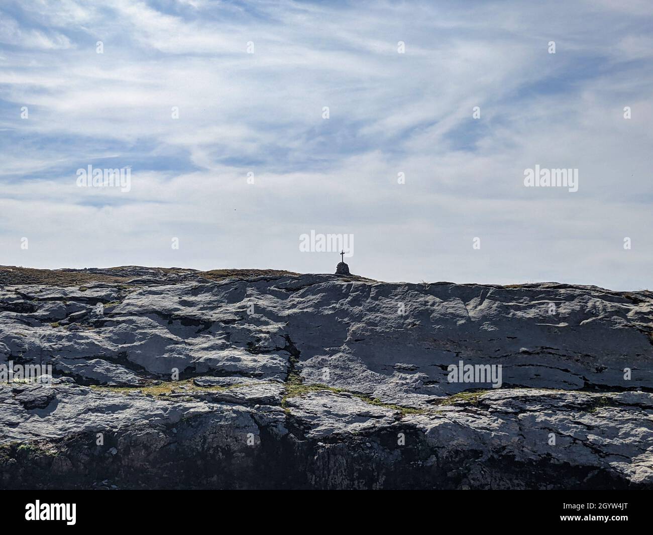 Gipfelkreuz in den schweizer Bergen mit Blick auf die Berggipfel und wunderschöne Almwiesen. Schönes Wanderwetter. Stockfoto