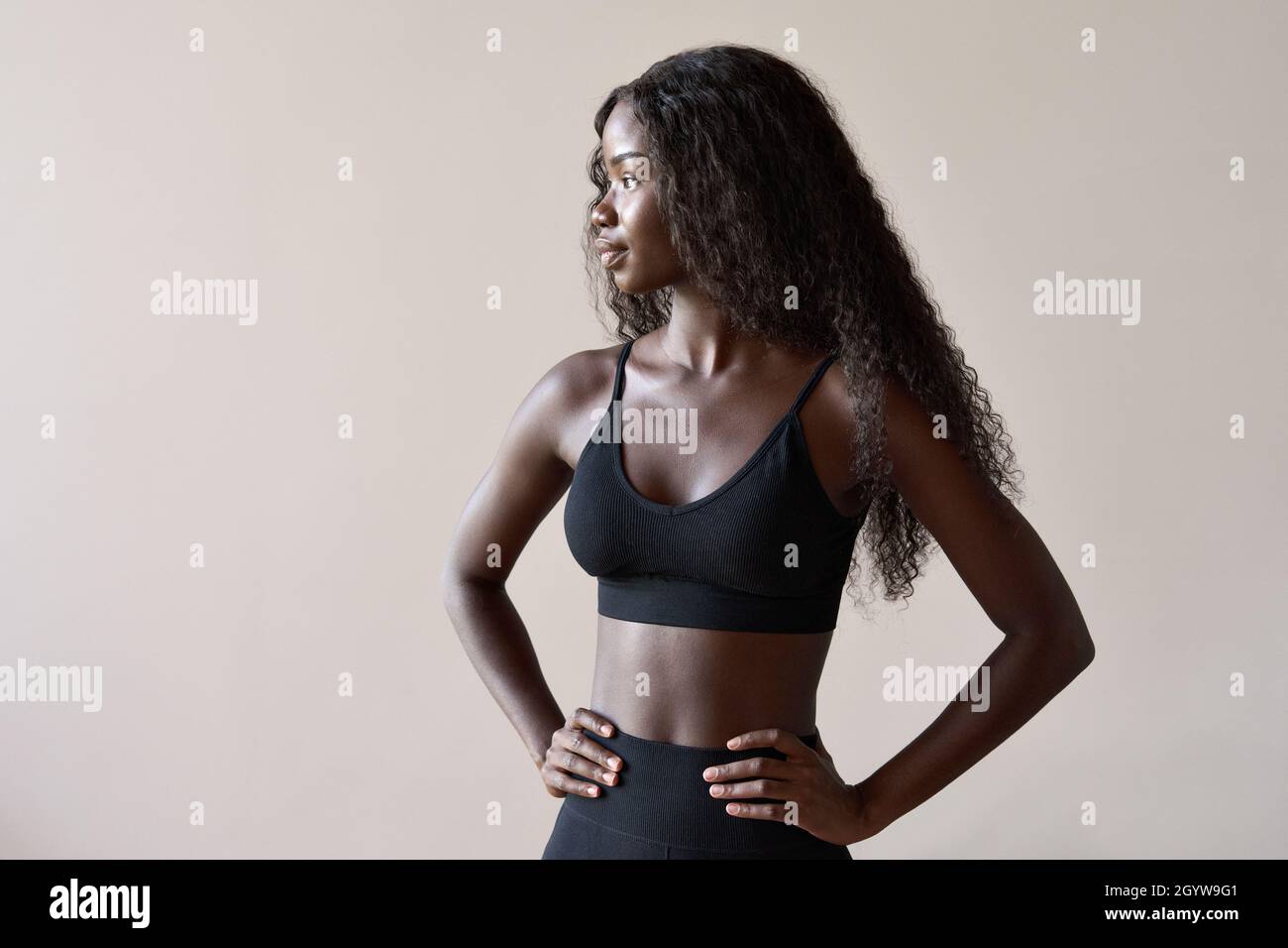 Junge fit gesunde afrikanische schwarze Frau auf graubraunem Hintergrund stehen. Stockfoto
