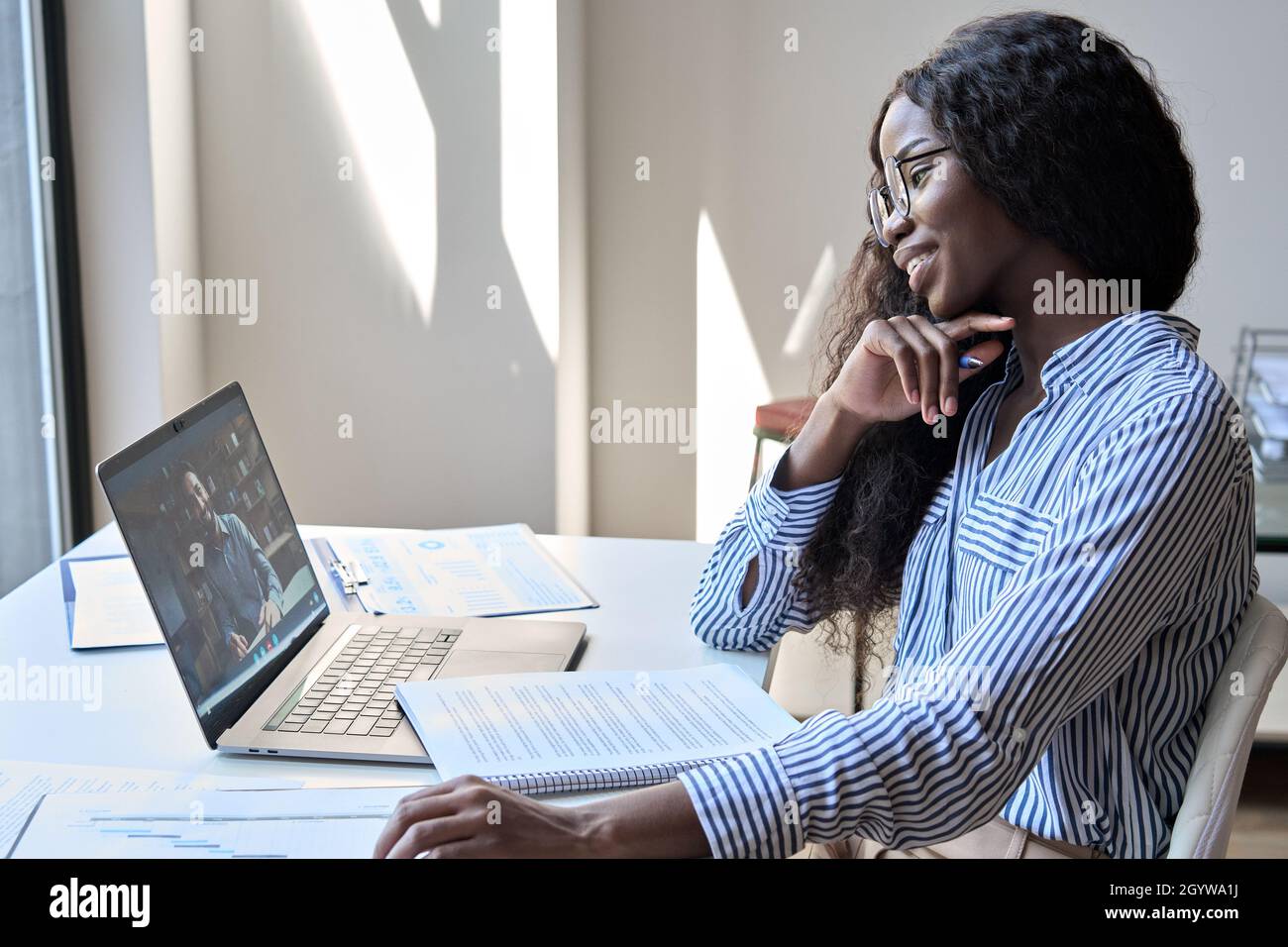 Glückliche schwarze Geschäftsfrau mit virtuellen Treffen mit indischen Mann Remote-Arbeit. Stockfoto