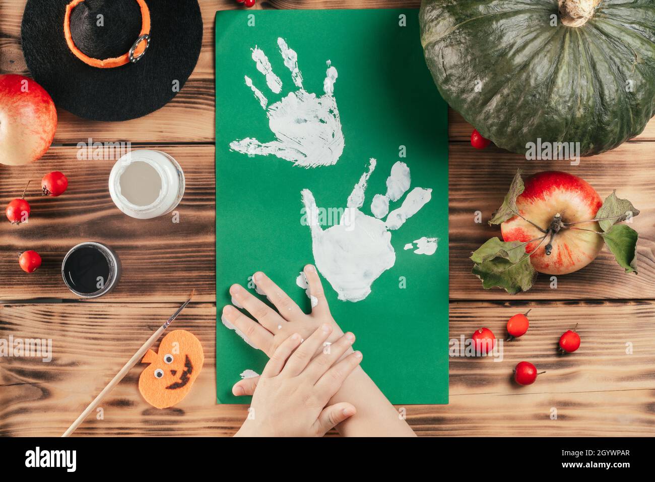 Schritt-für-Schritt Halloween Tutorial Geister Kinder Handprint. Schritt 6: Das Kind hinterlässt einen Handflächendruck auf einem farbigen Papier. Draufsicht Stockfoto