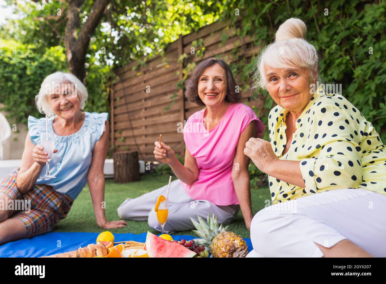 Schöne ältere Frauen, die sich zu Hause im Garten entspannen - drei  ziemlich reife Damen ruhen in einem ruhigen Garten im Hinterhof  Stockfotografie - Alamy