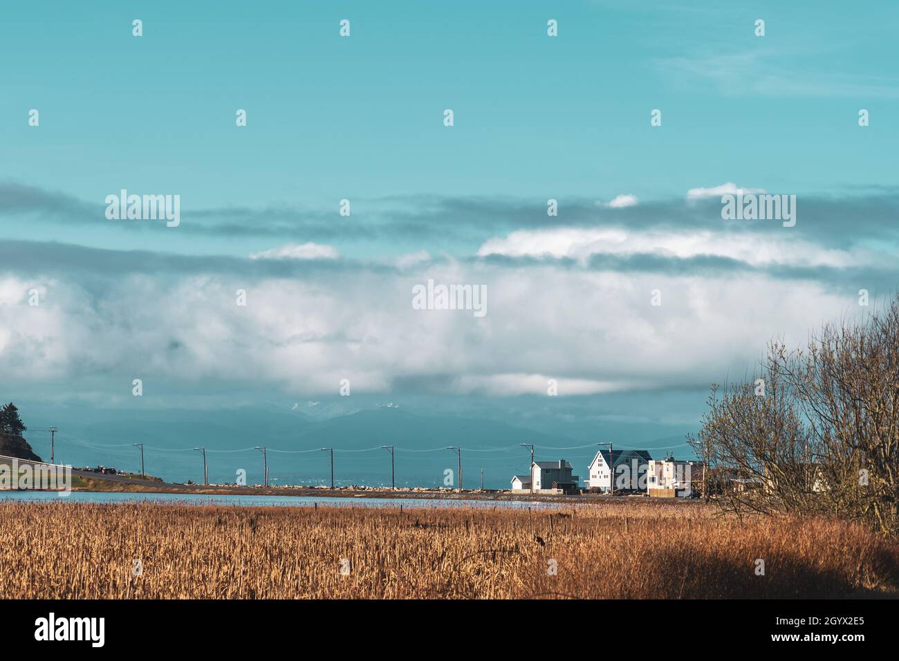 Nebelwolken heben sich am Morgen die Sonne fängt an, von Whidbey Island Wa aus die Olympischen Berge zu schwelgen. Stockfoto