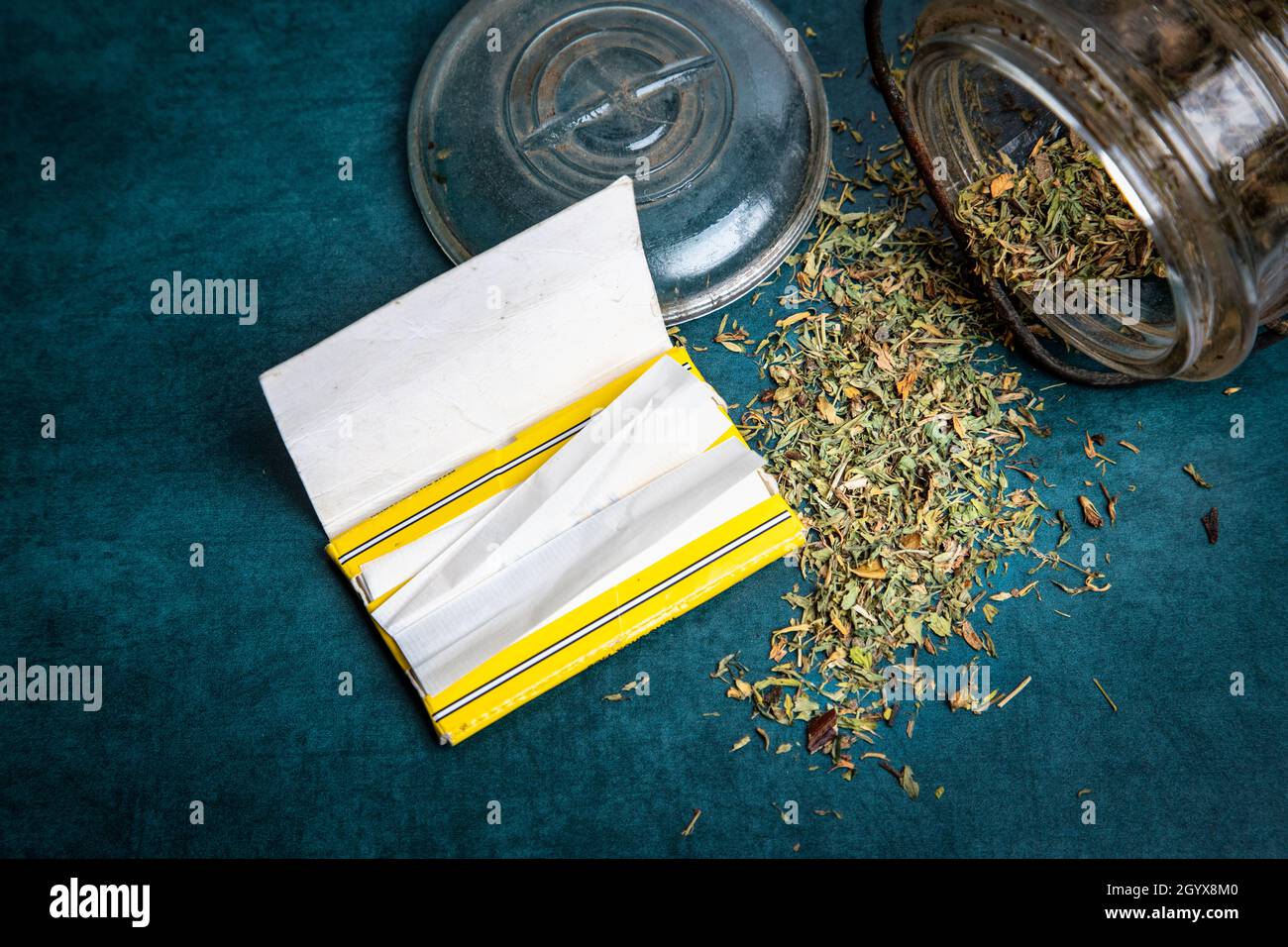 Getrocknetes Marihuana in einem Glas und Rollen Sie Ihr eigenes Papier Stockfoto