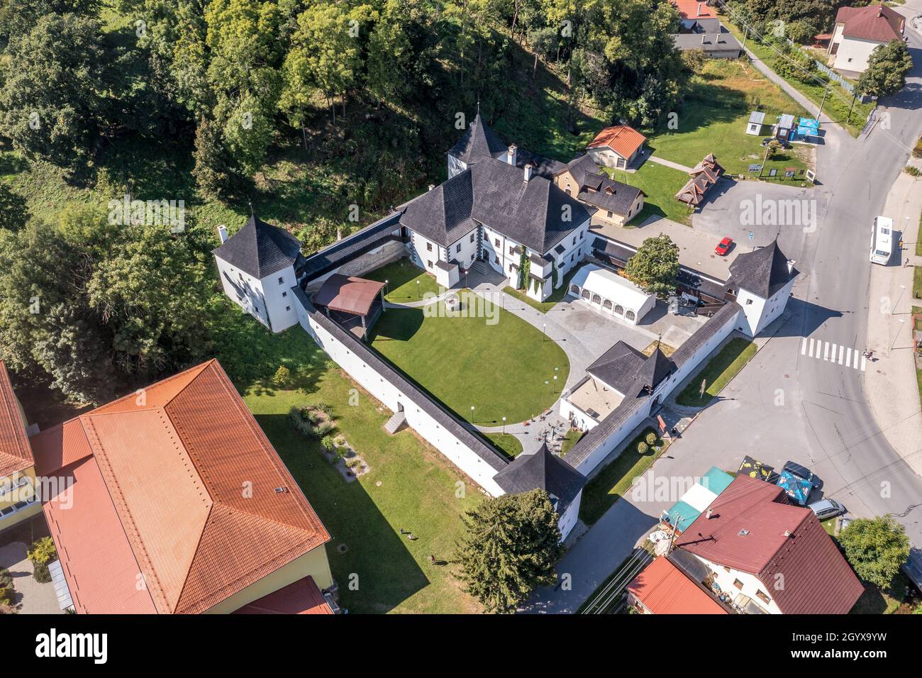 Luftaufnahme des Renaissance-Herrenhauses Schloss mit weißen Wänden, vier Ecktürme unter der Burgruine von Divin in der Slowakei Stockfoto