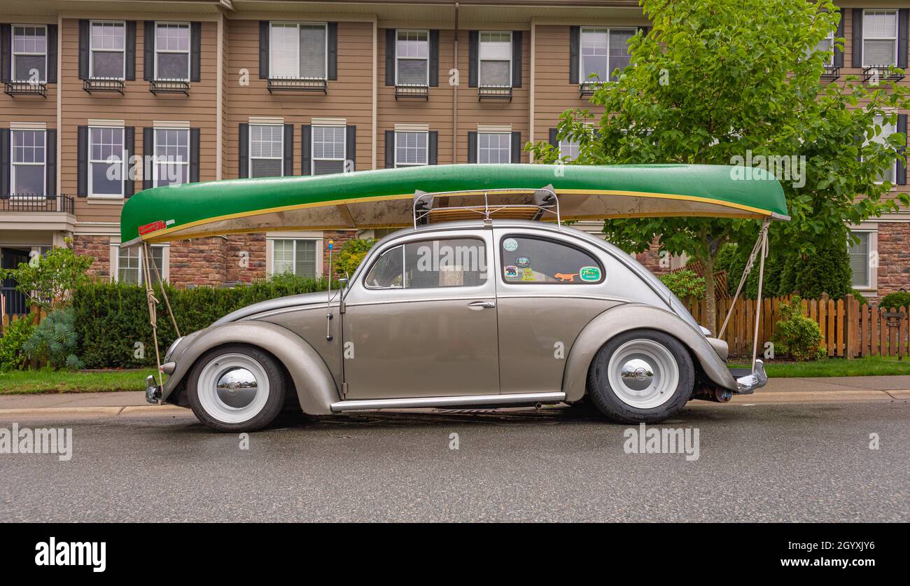 Klassischer Volkswagen Beetle mit Bootladung oben geparkt in einer Straße. Bereit für die Reise. Langley, BC, Kanada - September 8,2021. Blick auf die Straße, Reisen Stockfoto