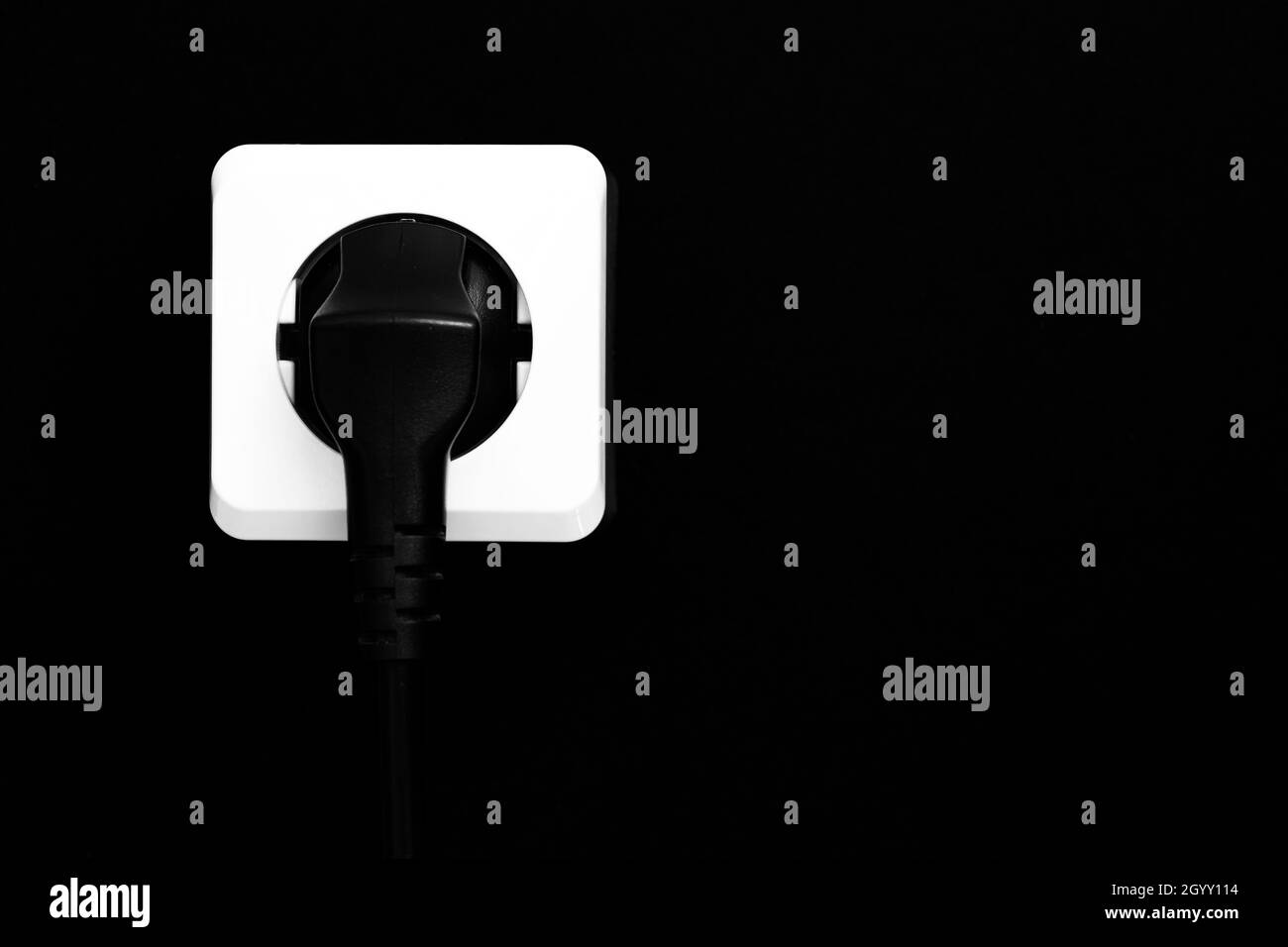 Weiße Buchse und schwarzer Stecker isoliert auf violettem Hintergrund Stockfoto