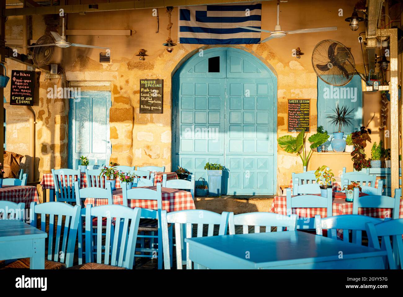 Typisches griechisches Restaurant mit blau bemalten Stühlen und Tischen am Hafen von Chania, Kreta, Griechenland Stockfoto
