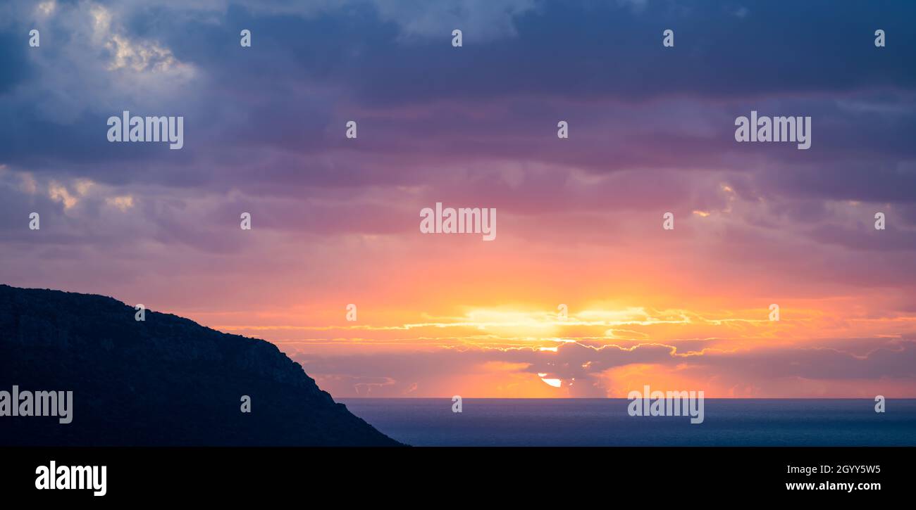 Natürlicher Hintergrund, atemberaubender Blick auf einen dramatischen, bewölkten Sonnenaufgang. Romantischer Himmel, Kopierraum, Himmelsersatz, Sardinien, Italien. Stockfoto