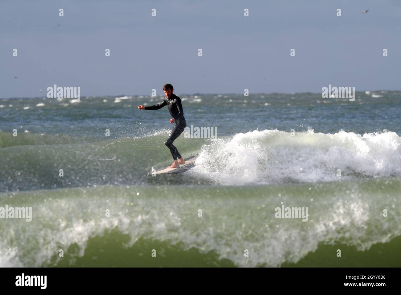 Surfen in einer der vielen geschützten Buchten von Gower Stockfoto