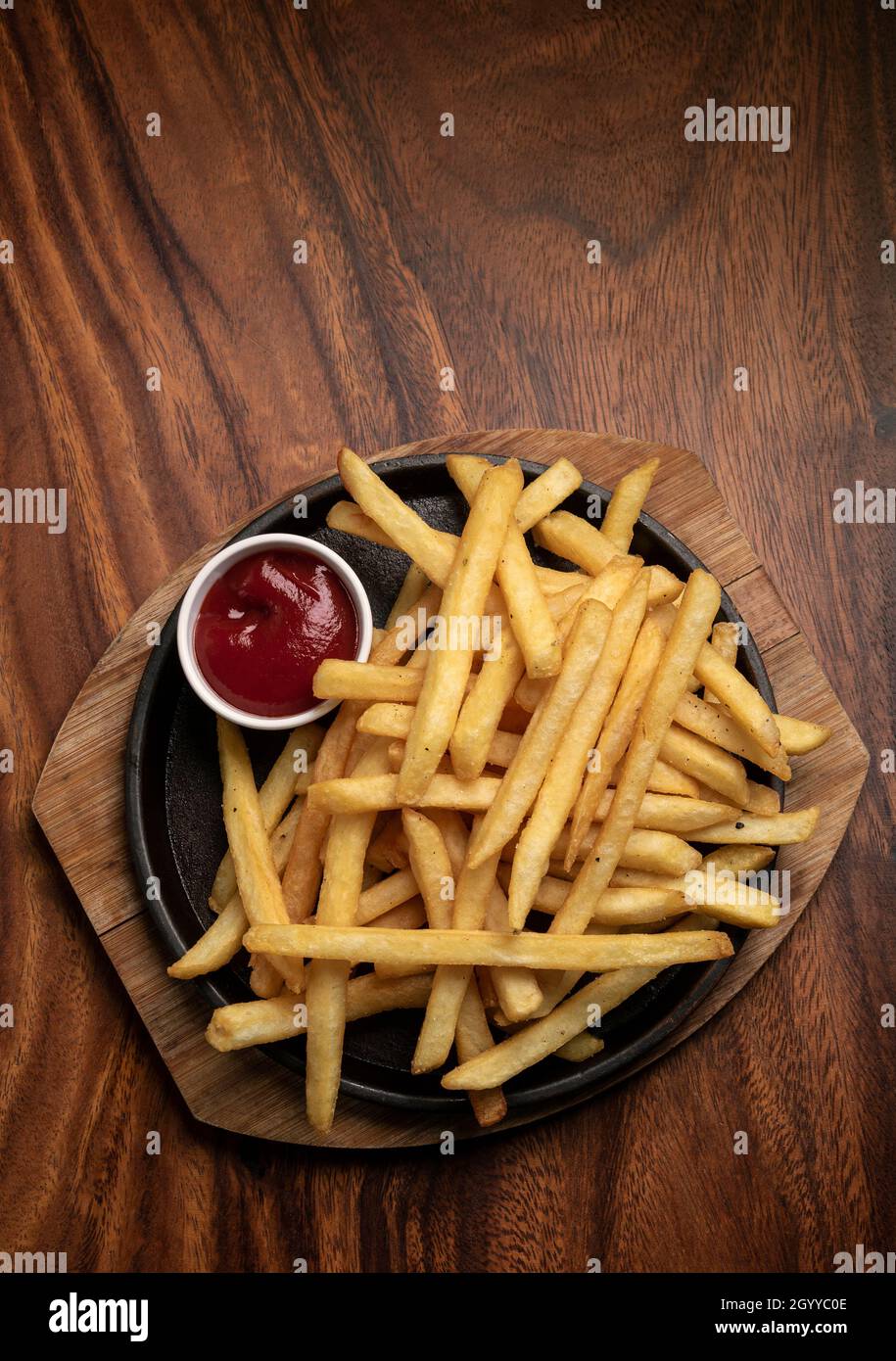 Portion pommes Frites Kartoffeljause auf Holztisch Hintergrund mit Ketchup im Restaurant Stockfoto