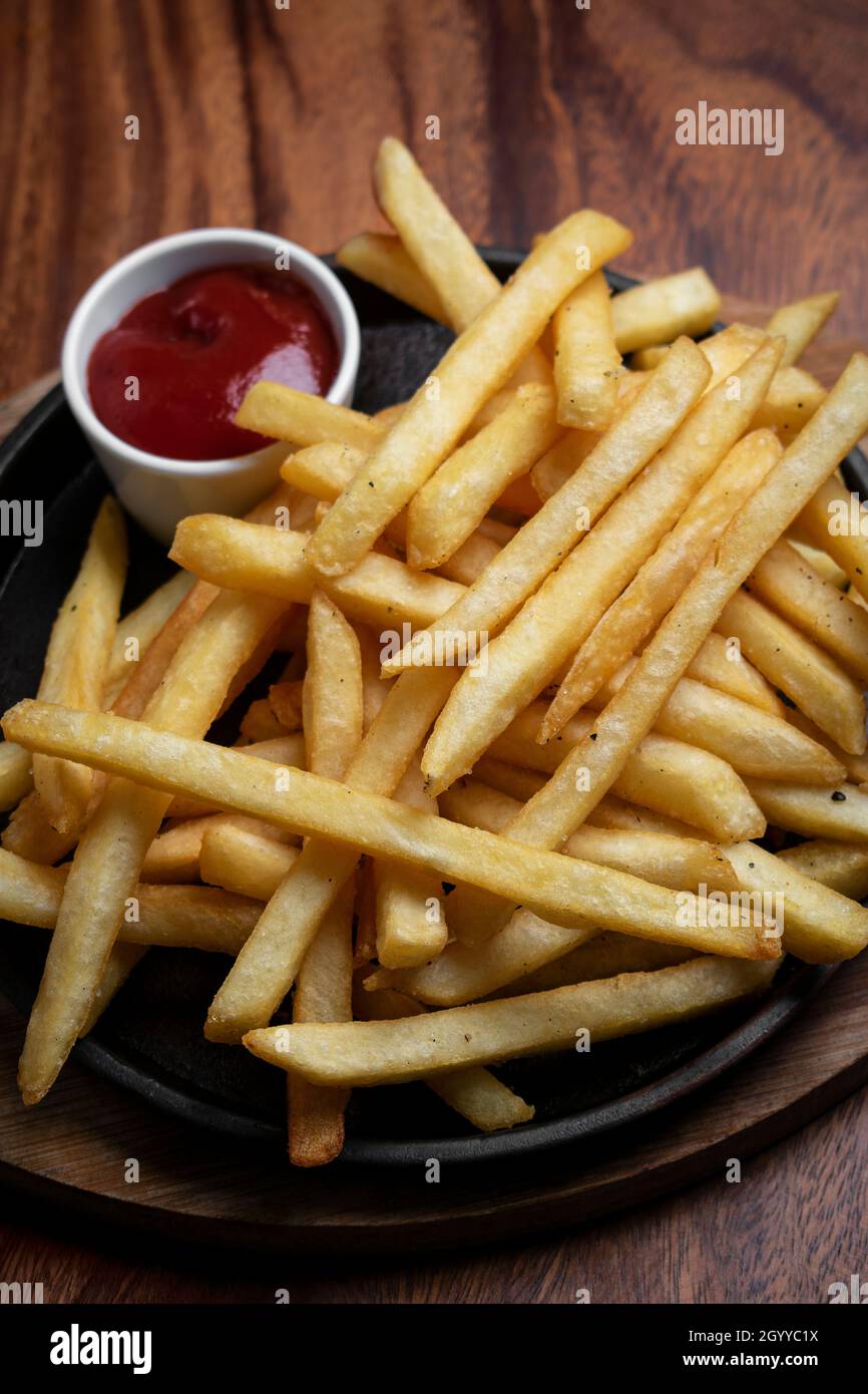 Portion pommes Frites Kartoffeljause auf Holztisch Hintergrund mit Ketchup im Restaurant Stockfoto