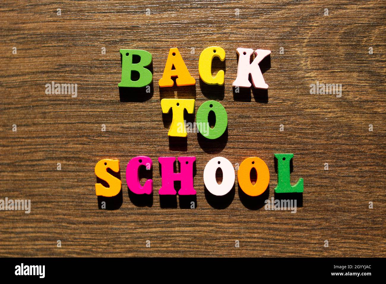 Inschrift der Worte des Slogans Back to School in mehrfarbigen Buchstaben mit Schatten auf einem schönen Hintergrund. Bunte Buchstaben des Alphabets Stockfoto
