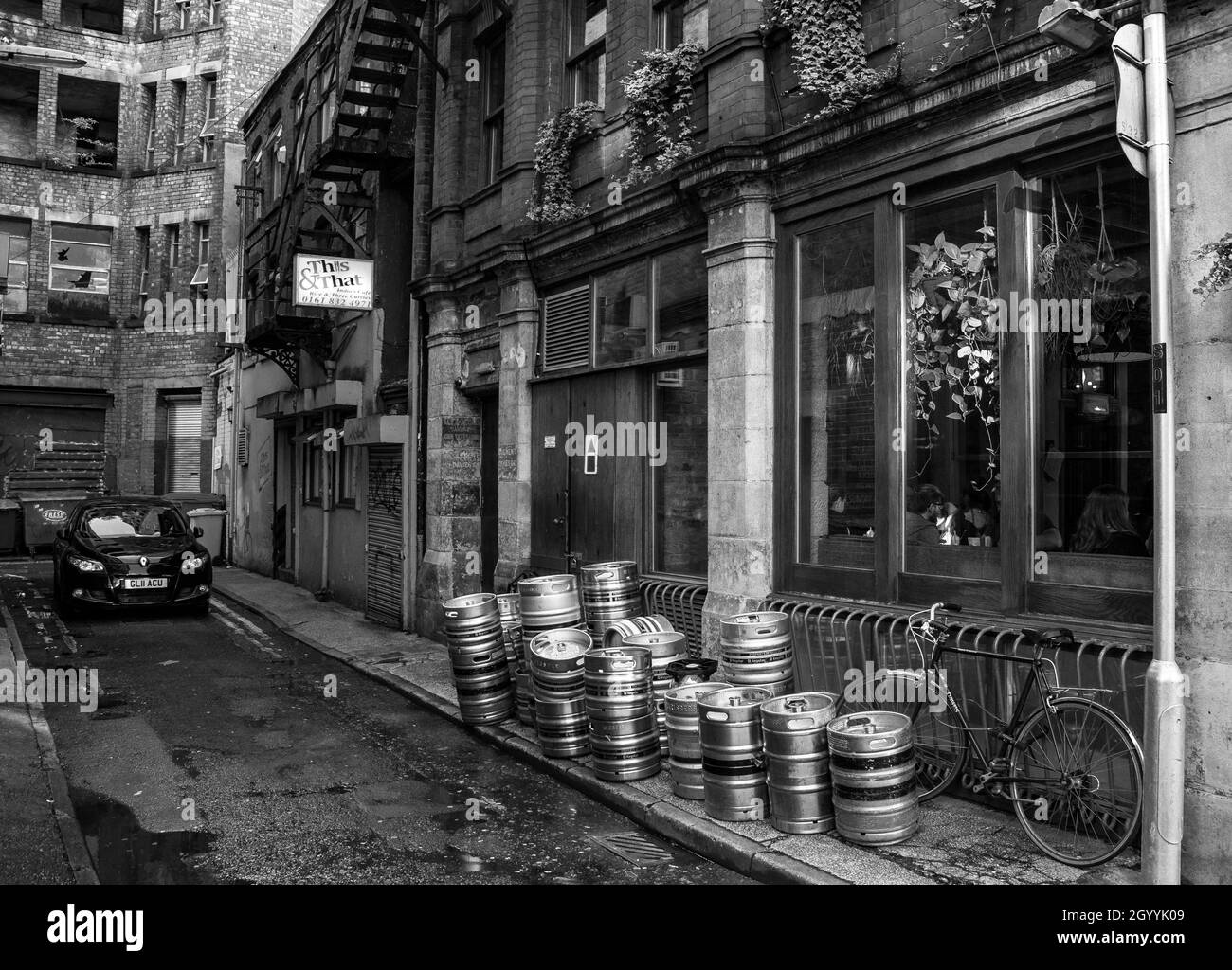 In einer Manchester-Seitenstraße gibt es This & That - ein Auto, Bierkegs, Treppen, ein Fahrrad und kaputte Fenster. Eine Reihe von Geschichten warten darauf, erzählt zu werden. Stockfoto