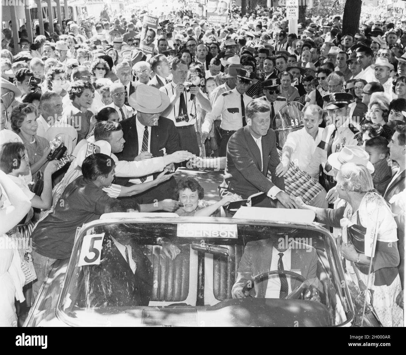 Senator John F. Kennedy (rechts) und Senator Lyndon B. Johnson (links mit Hut) werden zusammen mit Senator Kennedys Mutter Rose Kennedy (in der Mitte, im Auto sitzend) von Unterstützern begrüßt, als sie den Burnett Park auf dem Weg nach Dallas, Texas, verlassen. Die beiden waren im US-Bundesstaat, der sich für den Präsidenten- und den Vizepräsidentschaftsposten der USA auf der Democratic-Karte einsetzte. Fort Worth, Texas, 1960. Stockfoto