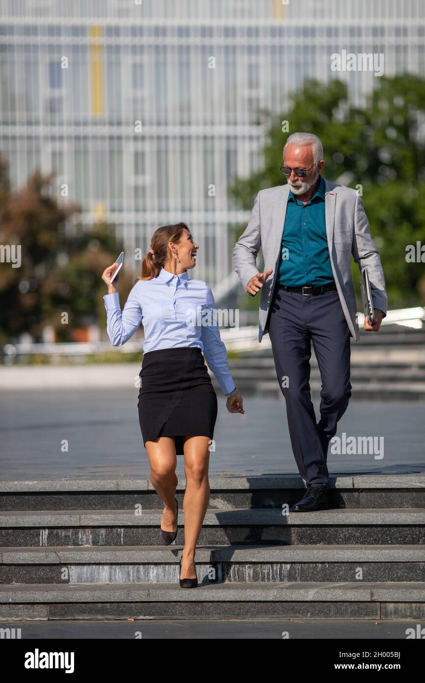 Geschäftsmann und -Frau gehen in Eile auf dem Stadtplatz, laufen auf Treffen, spät und in Eile Konzept Stockfoto