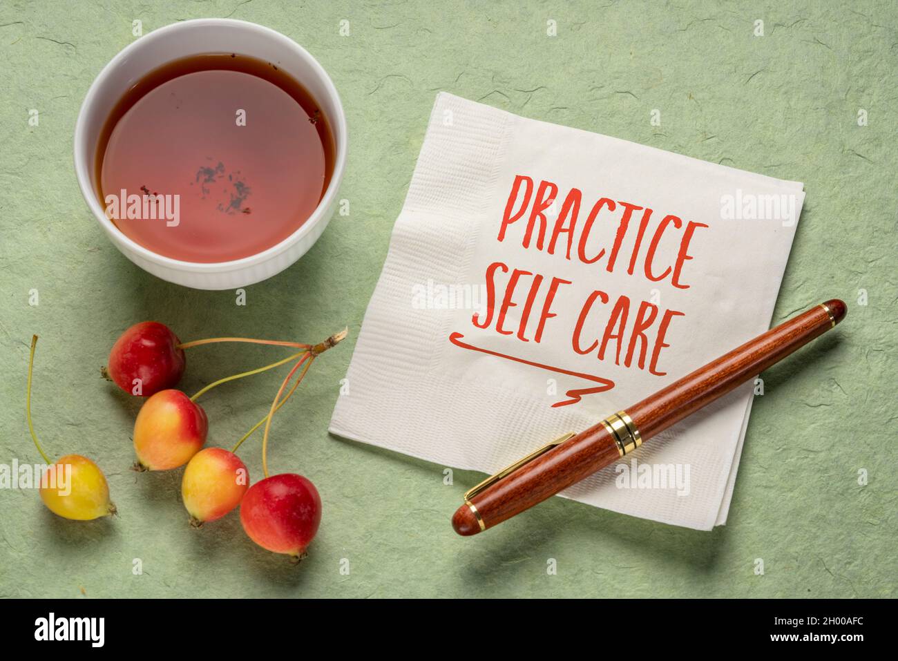 Üben Sie Selbstpflege - inspirierende Erinnerung, Handschrift auf einer Serviette mit einer Tasse Tee, Lifestyle und Gesundheitskonzept Stockfoto