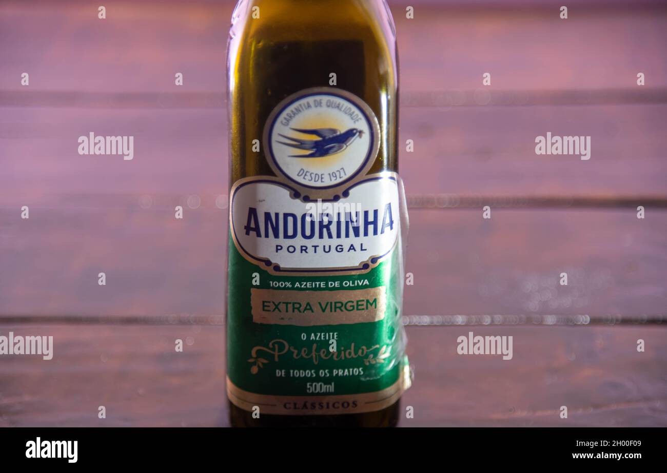 Olivenölflasche auf Holzhintergrund. Speiseöl. Verpackung zur Lagerung von Pflanzenöl. Produkt, das zum würzen von Lebensmitteln und Salaten verwendet wird. Stockfoto