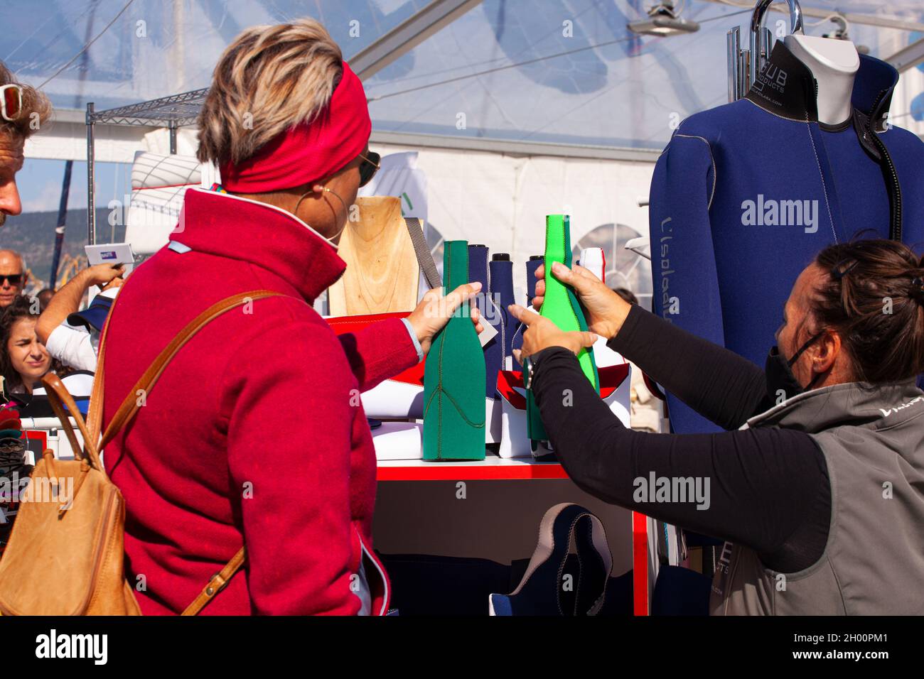 Triest, Italien - Oktober 09: Frau mit roter Jacke kauft am 09. Oktober 2021 in einem Fachgeschäft eine Neoprenflasche Stockfoto