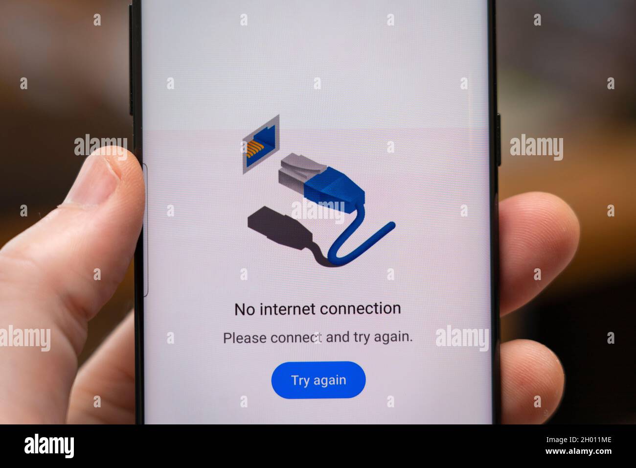 Die Hand eines Mannes, der ein Telefon mit einer Webseite auf einem Smartphone-Bildschirm hält und sagt: „Keine Internetverbindung“ Stockfoto