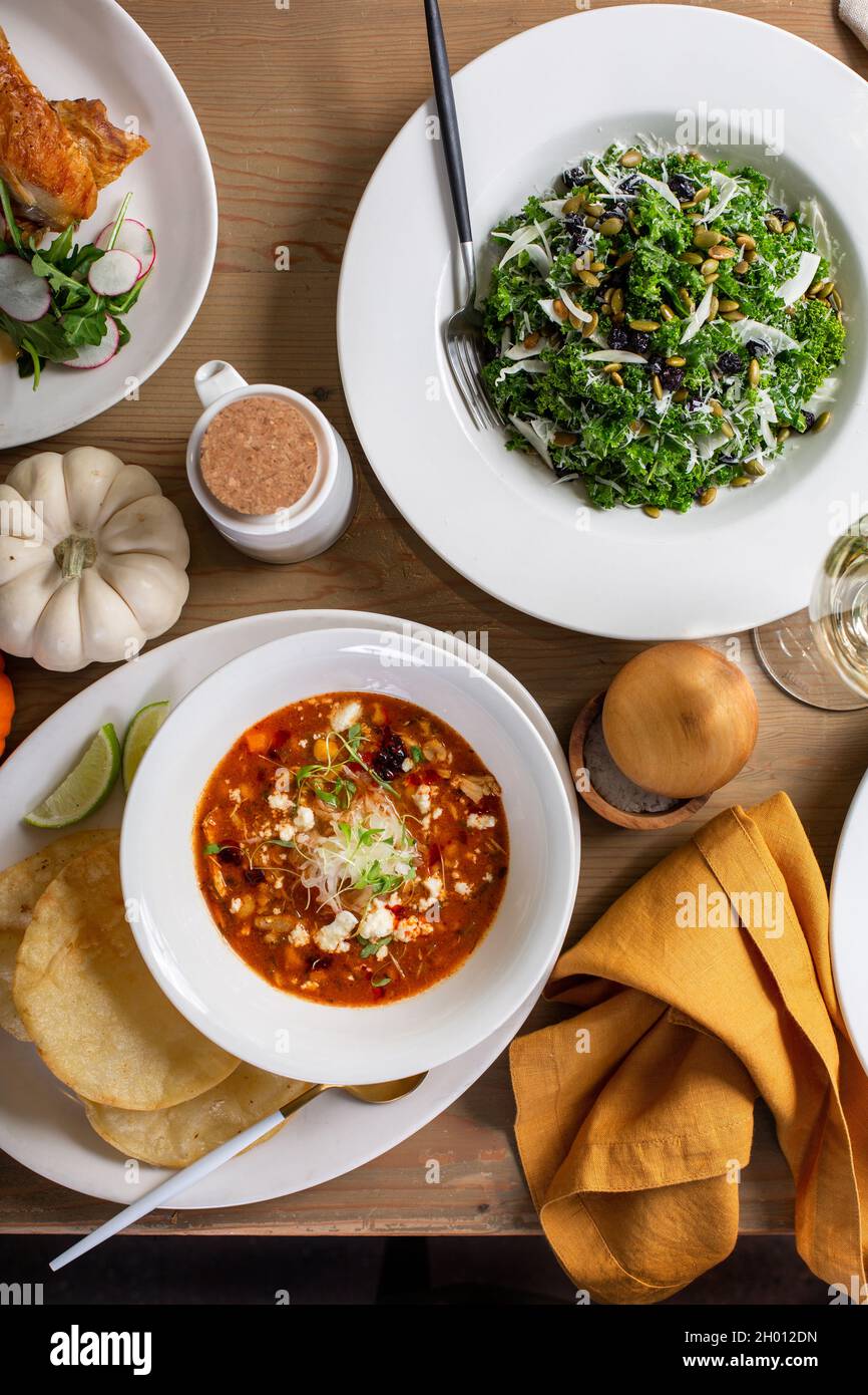 Herbst-Esstisch über dem Kopf mit Salat und Hauptgerichten Stockfoto