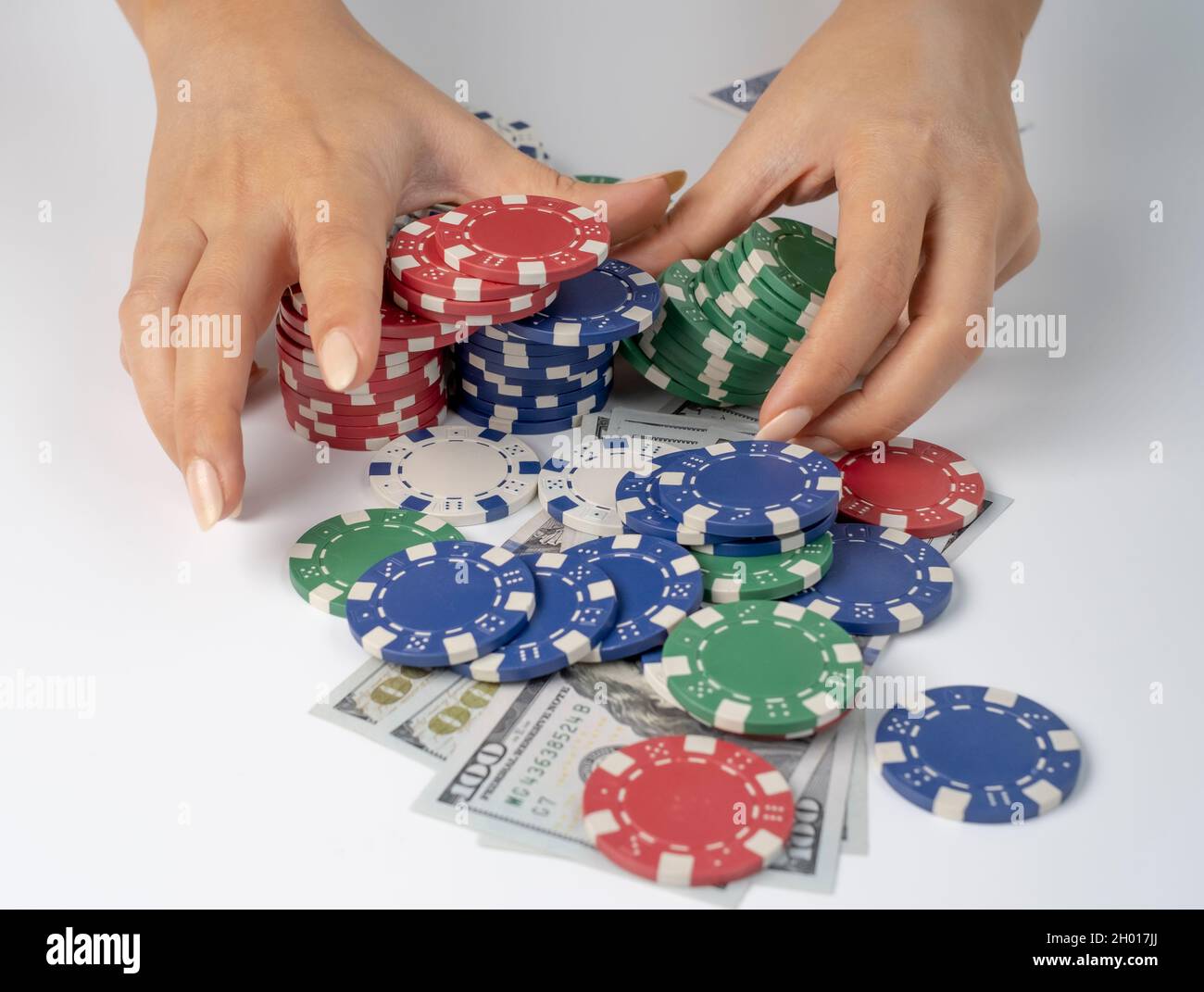 Hände schieben Stack-Chips nach vorne zum Wetten. Spielchips und Geld auf weißem Hintergrund. Alles in Las vegas zu verlieren. Stockfoto