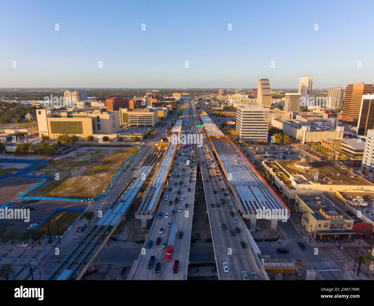 Luftaufnahme des Interstate Highway 4 I-4 in Downtown Orlando mit der Skyline des Central Business District bei Sonnenuntergang, Stadt Orlando, Florida FL, USA. Stockfoto