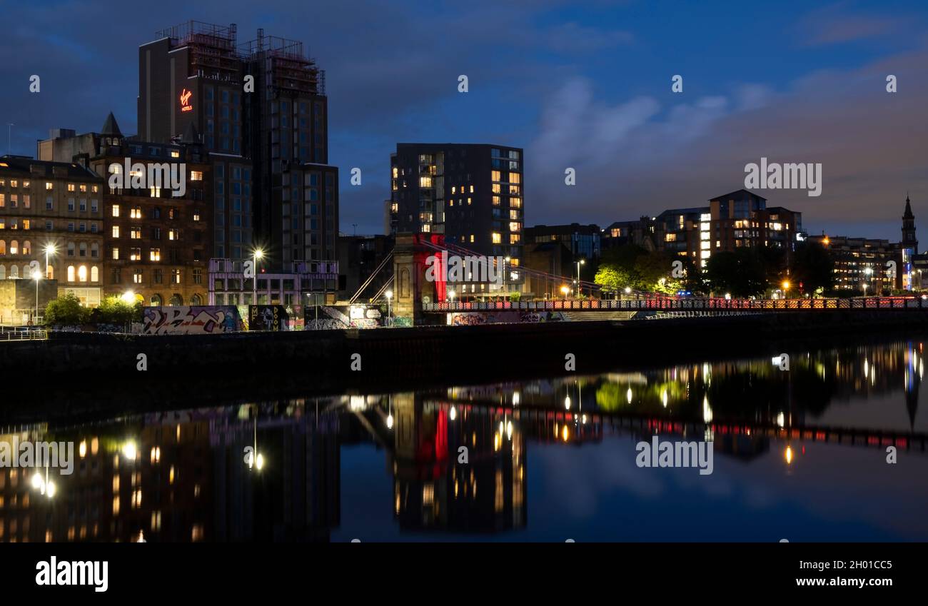Eine nächtliche Stadtansicht der Portland Street Suspension Bridge (Glasgow) und der umliegenden Gebäude. Aufnahme von der A77 Road am 4. Oktober 2021. Stockfoto