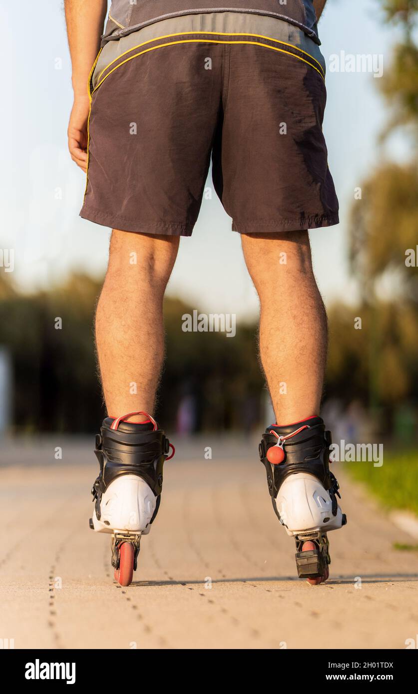 Vertikale Aufnahme der Beine eines Mannes beim Skaten mit Inline-Skates Stockfoto