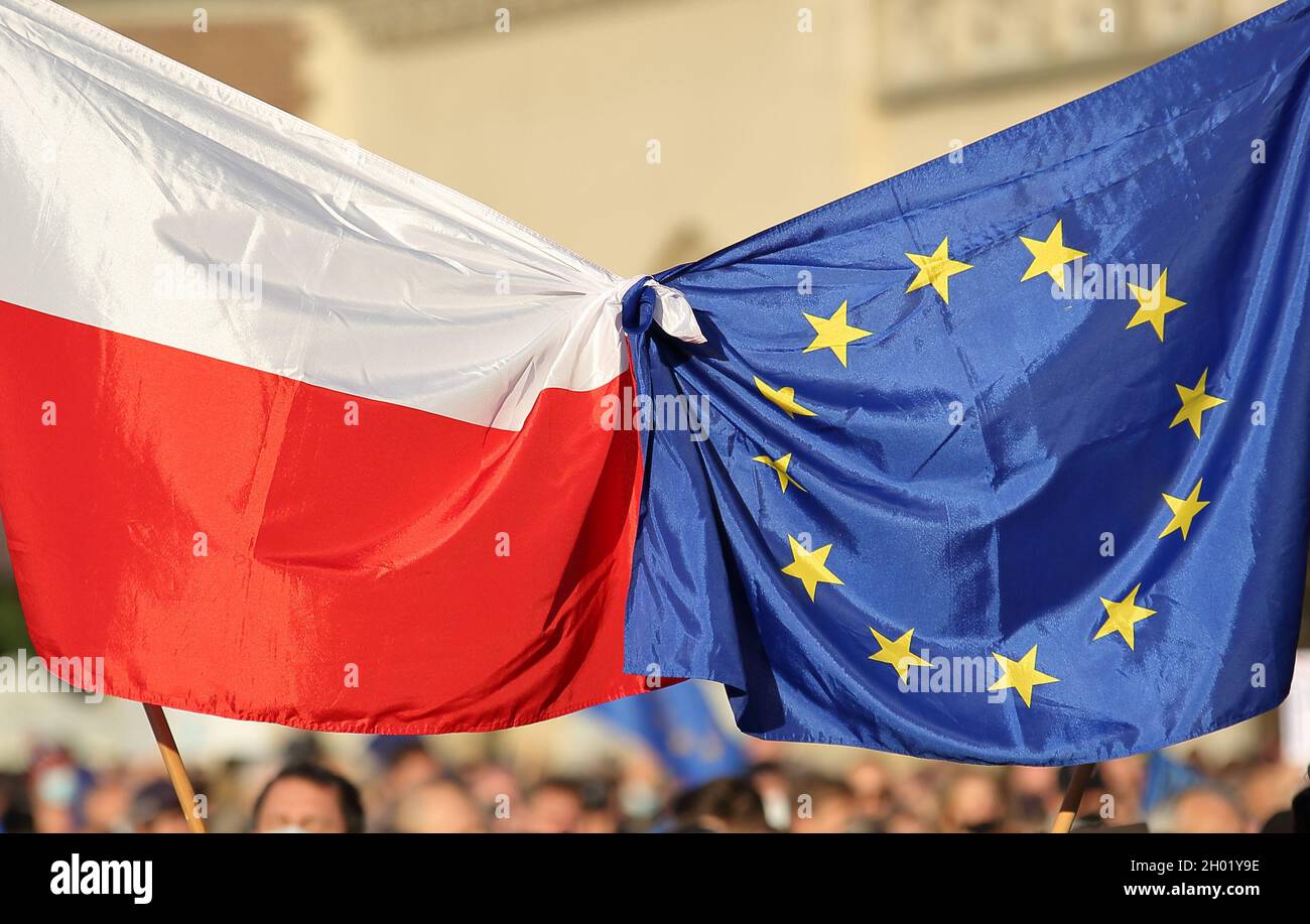Die Flaggen der Europäischen Union und Polens werden von Menschen zusammengebunden, die bei einer massiven öffentlichen Demonstration zur Unterstützung der Mitgliedschaft Polens in der EU protestieren Stockfoto