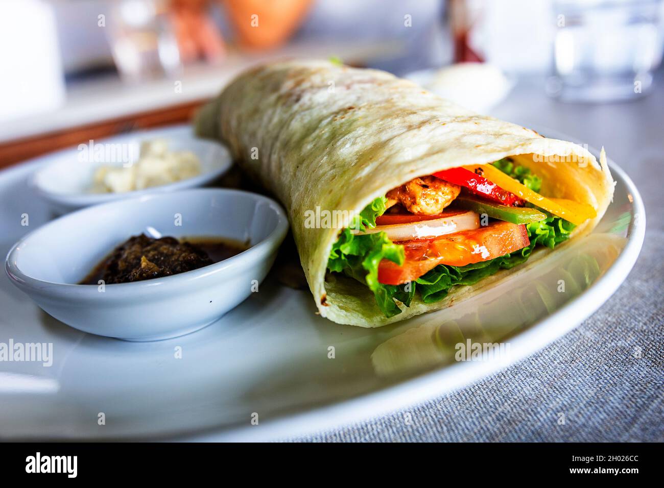 Ein Burrito, der in einem niedrigen Winkel fotografiert wurde und innen auf eines der Enden der gerollten Tortilla blickt. Stockfoto