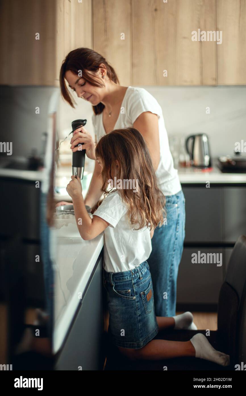 Mama und Tochter bereiten in ihrer heimischen Küche das Eis für ...
