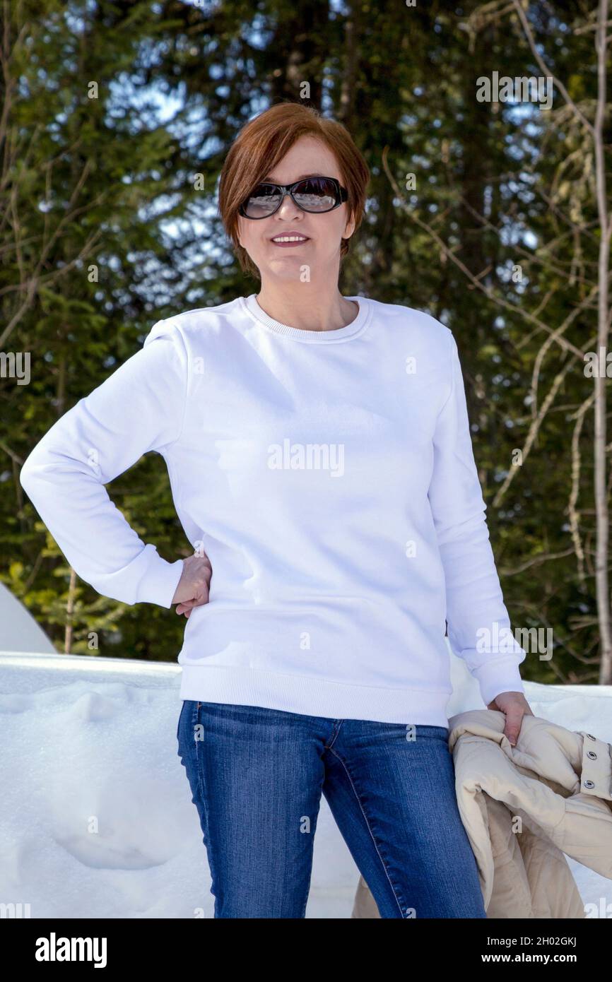 Weißes Fleece-Sweatshirt mit Rundhalsausschnitt und einer Frau im Winterwald. Schwere Sweatshirt Vorlage, Modell Mockup Stockfoto