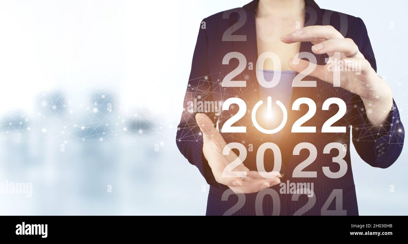 2022 Neujahr. Zwei Hand halten virtuelle holographische 2022 Symbol mit hellen unscharfen Hintergrund. Frohes Neues Jahr 2022. Erfolg im neuen Jahr Konzept.Business ma Stockfoto