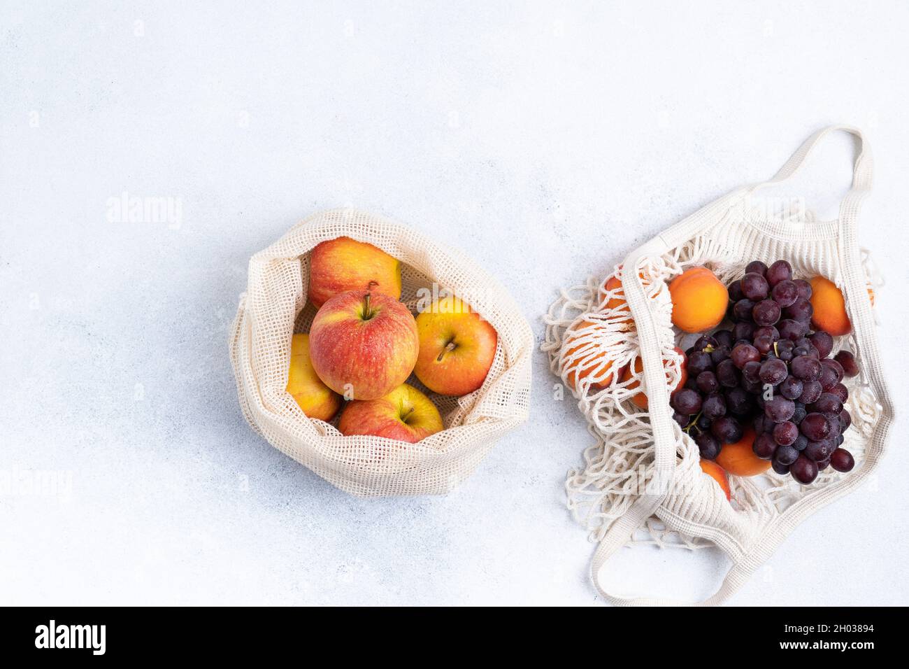 Äpfel und Trauben in einem Öko-Beutel bewirtschaften. Zero Waste Konzept Stockfoto