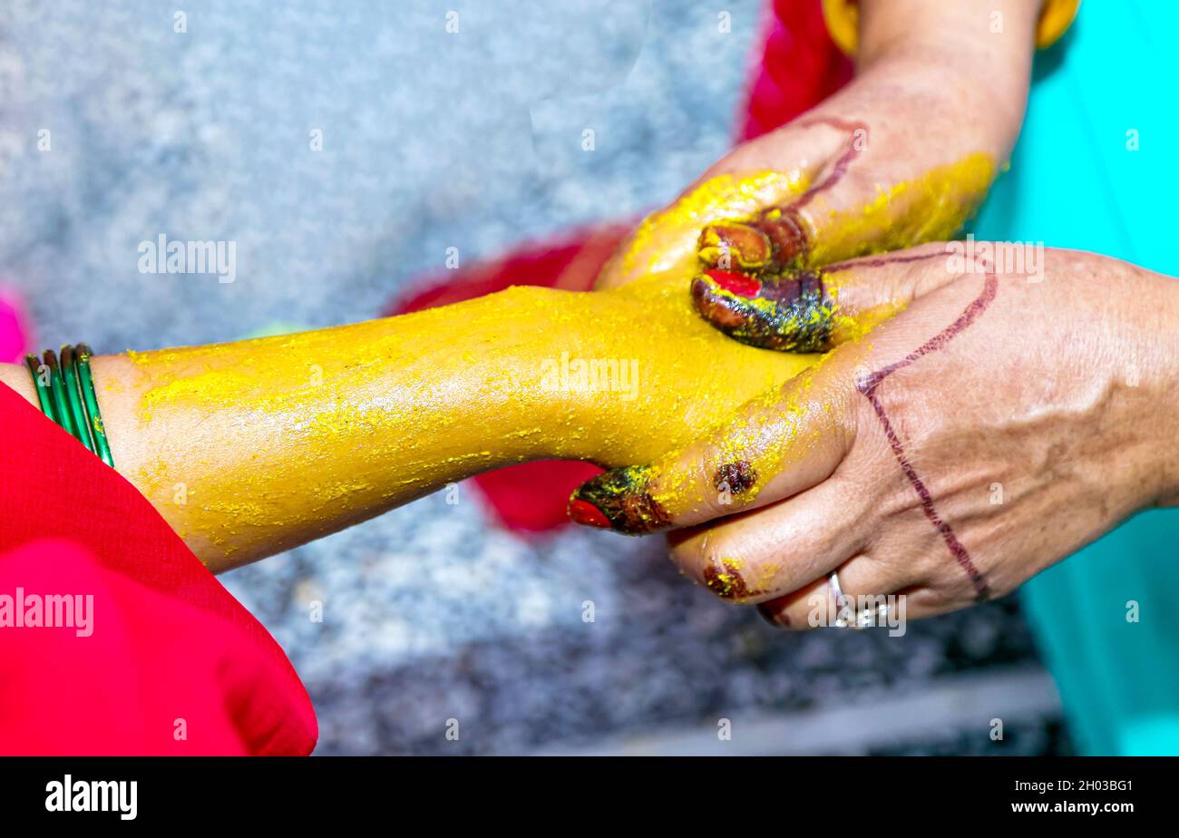 Eine indische Braut Kurkuma haldi Paste auf ihre Hand Stockfoto
